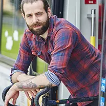 Mann mit Bart lehnt sich über sein Fahrradlenkrad