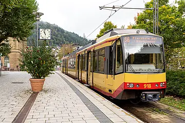 Eine AVG-Stadtbahn steht an der Haltestelle Bad Wildbad Kurpark mit geöffneten Türen. 