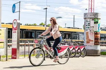 Eine Frau fährt auf einem KVV.nextbike-Fahrrad durch Karlsruhe