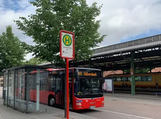Ein Bus der Linie 101 steht an einer Haltestelle am Ettlinger Stadtbahnhof. Im Hintergrund hält eine Stadtbahn der AVG.
