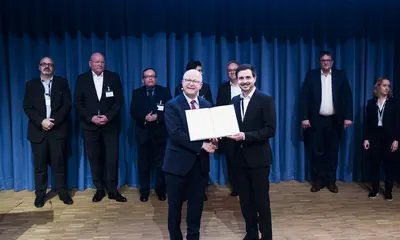 Das Foto zeigt Staatssekretär Michael Theurer bei der Übergabe einer Urkunde an VBK-Projektleiter Ruben Jerke. 