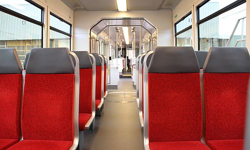 Rot-graue Sitze ohne Fahrgäste in einer Stadtbahn der AVG.