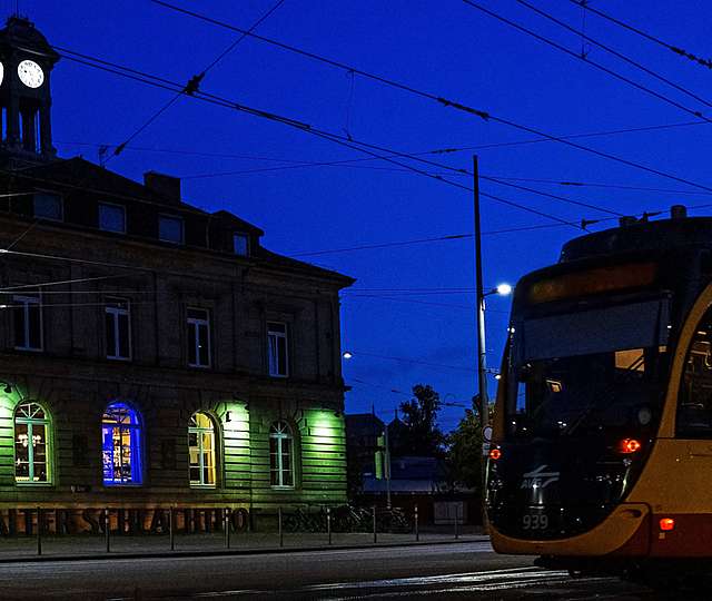 Eine KVV-Bahn fährt nachts durch die Karslruher Stadt.