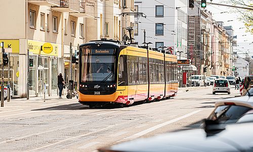 Gelb-rote Straßenbahn in der Karlsruher Karlstraße vor einer Häuserzeile