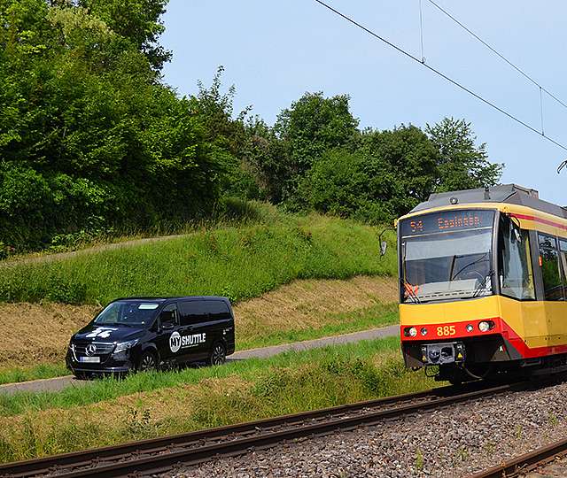 Das KVV.MyShuttle fährt neben einer KVV-Bahn.