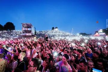 Besucher*innen des Festivals "Das Fest" stehen abends vor der Hauptbühne