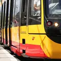 Zwei Frauen steigen in eine Niederflurbahn ein. Eine der Frauen hat einen Rollator.