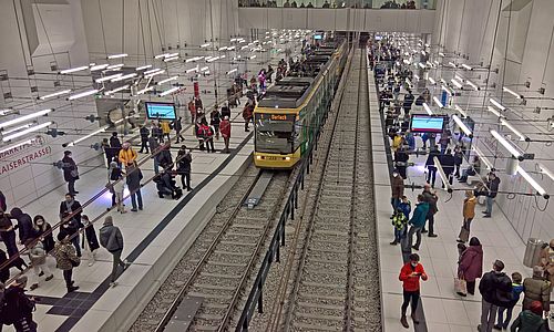 Eine Haltestelle im Stadtbahntunnel mit Fahrgästen an den Bahnsteigen und einer einfahrenden Bahn