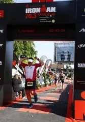 Ein Sportler überquert die Ziellinie beim Ironman Kraichgau