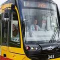 Ein Bahnfahrer sitzt lächelnd in der Fahrerkabine.