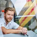 Ein Lokführer sitzt in der Lokführerkabine einer Bahn.