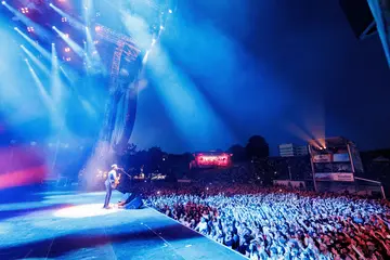 Der Sänger Passenger steht abends auf der Bühne von "Das Fest". Vor der Bühne stehen Zuschauer*innen. 