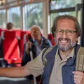 Ein älterer Mann mit Rucksack steht in der Bahn.