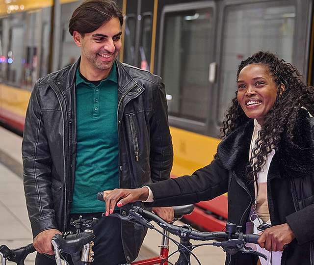 Eine Frau und ein Mann steigen mit ihren Fahrrädern aus einer KVV-Bahn.
