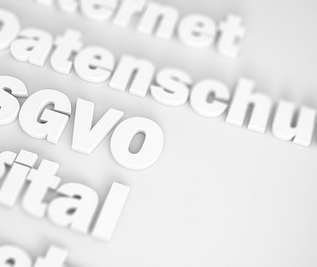 Illustration von Worten in weiß, die aus einem weißen Hintergrund hervortreten. Zu erkennen sind die Worte DSGVO, Datenschutz und digital.