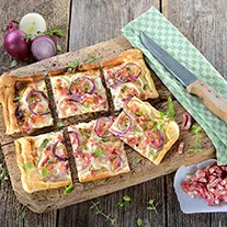 Flamkuchen auf einem Holzbrett