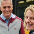 Eine Familie mit Kindern fährt in einer Bahn. Sie schauen aus dem Fenster. Der Mann zeigt auf etwas draußen.