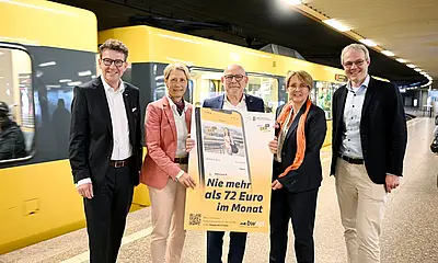 Das Foto zeigt von links nach rechts Prof. Dr. Alexander Pischon (Geschäftsführer Karlsruher Verkehrsverbund und Vorsitzender der VDV-Landesgruppe Baden-Württemberg), Simone Stahl (Geschäftsführerin Regio-Verkehrsverbund Freiburg), Winfried Hermann (Verkehrsminister Baden-Württemberg), Cornelia Christian (Geschäftsführerin Verkehrs- und Tarifverbund Stuttgart) und Dr. Jan Neidhardt (Geschäftsführer Verkehrs- und Tarifverbund Stuttgart). Sie stehen alle nebeneinander in einer U-Bahn-Haltestelle in Stuttgart und präsentieren ein Plakat zur neuen Preisobergrenze für das E-Ticketin "CiCoBW"