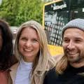 Drei Kinder stehen im Kreis und halten sich gegenseitig.