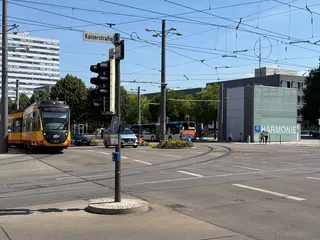 Eine AVG-Bahn biegt an der Haltestelle Harmonie in Heilbronn nach links ab. 