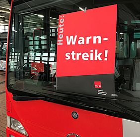 Frontscheibe eines Busses mit einem Plakat der Gewerkschaft verdi.