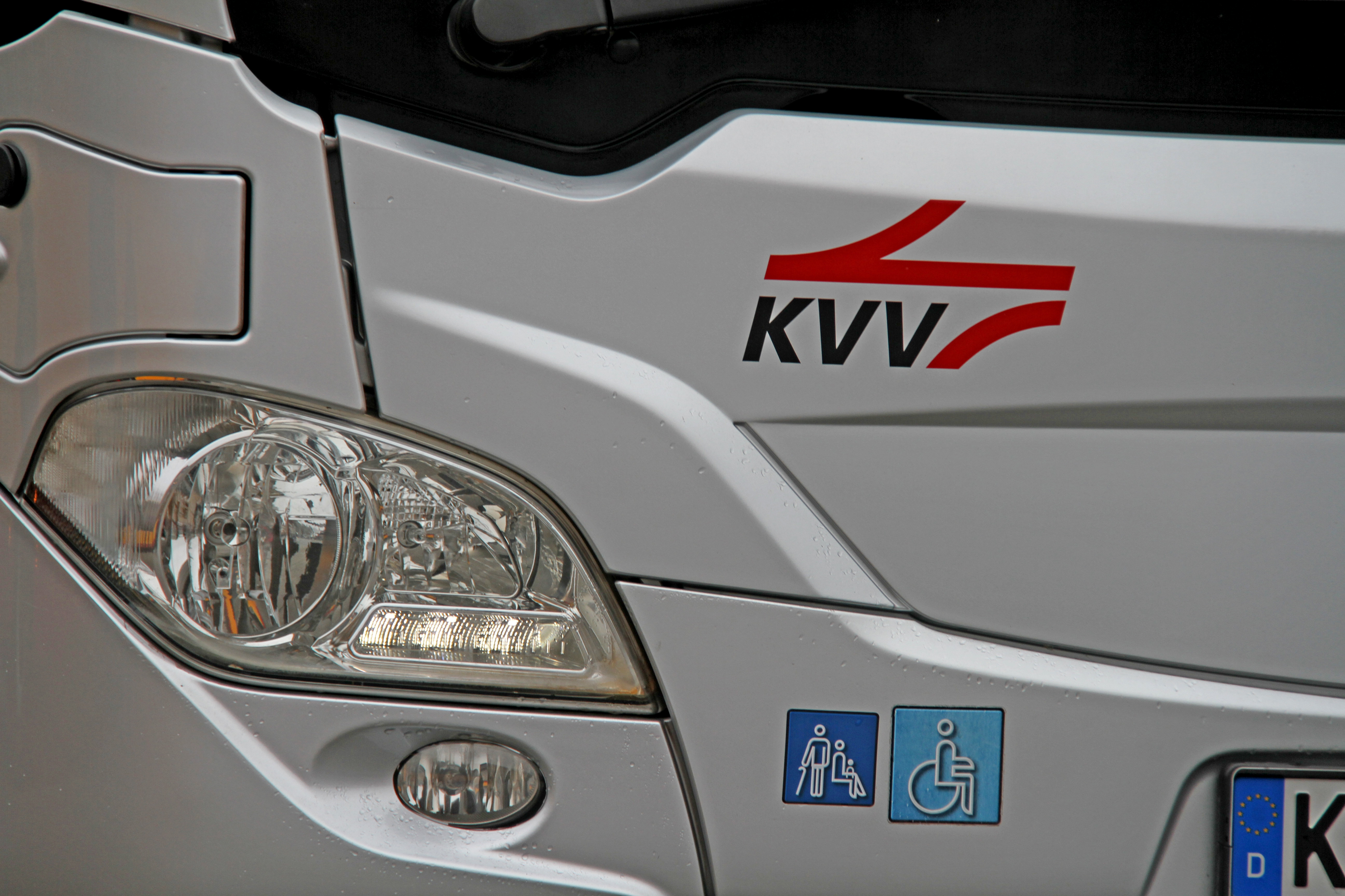 Scheinwerfer eines silberfarbenen Busses mit rotem KVV-Logo